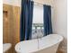 Bright bathroom with soaking tub, glass-enclosed shower, and tiled walls at 15313 Moate Ct, Huntersville, NC 28078