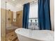 Bathroom featuring soaking tub, glass-enclosed shower, and tiled walls at 15313 Moate Ct, Huntersville, NC 28078