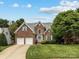Beautiful brick home with a well-manicured lawn and garden, showcasing curb appeal at 15313 Moate Ct, Huntersville, NC 28078