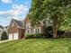 Stately brick home with a manicured lawn, attached two car garage and blue shutters at 15313 Moate Ct, Huntersville, NC 28078