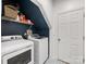 Modern laundry room with front loading washer and dryer and storage shelf with supplies for added convenience at 15313 Moate Ct, Huntersville, NC 28078