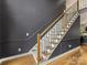 Elegant staircase featuring hardwood steps, carpet runner, iron spindles, and stained wood banister at 15313 Moate Ct, Huntersville, NC 28078
