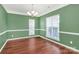 Bright dining room featuring hardwood floors, green walls, and natural light from two windows at 1618 Bay Meadows Nw Ave, Concord, NC 28027