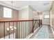 Upstairs hallway with wood railing, and views of the home's foyer at 1618 Bay Meadows Nw Ave, Concord, NC 28027
