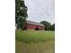 Rustic red barn nestled in a grassy field, showcasing the property's agricultural charm at 18070 Old Beatty Ford Rd, Gold Hill, NC 28071