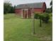 Quaint silo next to a red barn set in a verdant field, capturing the essence of rural living at 18070 Old Beatty Ford Rd, Gold Hill, NC 28071