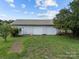 Detached two-car garage with white doors, nestled in a green lawn at 18070 Old Beatty Ford Rd, Gold Hill, NC 28071