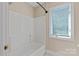 Clean bathroom with a tub, shower, and a bright window at 2045 10Th Street Nw Ln, Hickory, NC 28601