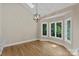 Bright dining area with hardwood floors, modern chandelier, and large windows offering green views at 2045 10Th Street Nw Ln, Hickory, NC 28601