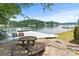 Lakeside patio with stone table and chairs, ideal for outdoor dining and entertaining with a view at 2045 10Th Street Nw Ln, Hickory, NC 28601