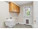 Functional laundry room with a utility sink, storage cabinets, and a pet door for added convenience at 2045 10Th Street Nw Ln, Hickory, NC 28601