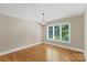 Bright room featuring hardwood floors, a modern chandelier, and a large window with natural light at 2045 10Th Street Nw Ln, Hickory, NC 28601