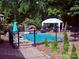 Backyard pool area features a gazebo, lounge chairs, and privacy fencing, creating a perfect outdoor retreat at 208 Stone Ridge Dr, Salisbury, NC 28146