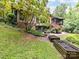 Backyard with wooden patio, planters, lush greenery and mature trees for a private outdoor oasis at 218 Point Carpenter Rd, Fort Mill, SC 29707