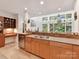Charming kitchen features an abundance of natural light with multiple windows and wood cabinets at 218 Point Carpenter Rd, Fort Mill, SC 29707