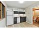 A compact kitchenette with black cabinets, a sink, and sleek white appliances at 218 Point Carpenter Rd, Fort Mill, SC 29707