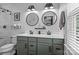 Bright bathroom features double sinks, round mirrors, and a shower with glass doors at 2444 Mariners Cove Ln, Denver, NC 28037