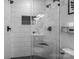This bathroom features black hardware, a glass shower, white tile, and hexagon flooring at 2444 Mariners Cove Ln, Denver, NC 28037
