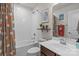 Bright bathroom featuring a tub with tile surround, a vanity with a sink, and decorative accents at 2444 Mariners Cove Ln, Denver, NC 28037