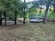 Backyard scene featuring mature trees, newly installed fencing, and the house viewed from the yard at 295 Rendleman Rd, Salisbury, NC 28146