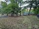 Large grassy backyard with mature trees and a view of the house and surrounding landscape at 295 Rendleman Rd, Salisbury, NC 28146