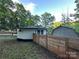 Cozy home exterior surrounded by mature trees, a newly installed fence, and scenic landscaping at 295 Rendleman Rd, Salisbury, NC 28146