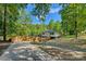 Exterior view of a home with a long driveway and a wooden fence surrounded by trees at 295 Rendleman Rd, Salisbury, NC 28146