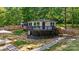 Charming elevated home with wood deck, stone pathway, and wooded surroundings at 295 Rendleman Rd, Salisbury, NC 28146