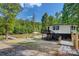 Waterfront home featuring deck, lakeside lounge area, dock, and lush landscaping on a sunny day at 295 Rendleman Rd, Salisbury, NC 28146