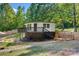 Charming elevated home with wood deck, stone pathway, and wooded surroundings at 295 Rendleman Rd, Salisbury, NC 28146