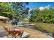 Relaxing lakeside setup with a dock, lounge chairs, and a fire pit amidst mature trees at 295 Rendleman Rd, Salisbury, NC 28146