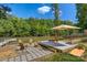 Inviting lakeside patio setup with lounge chairs, fire pit, and a dock surrounded by greenery at 295 Rendleman Rd, Salisbury, NC 28146