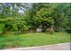 Lush backyard features mature trees, green lawns, and storage shed at 317 Cedarcroft Dr, Mooresville, NC 28115