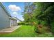 View of the backyard featuring a screened-in porch and patio with lawn and natural landscape at 317 Cedarcroft Dr, Mooresville, NC 28115