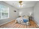 Bedroom with a floral bedspread, wood floors, ceiling fan, and natural light at 317 Cedarcroft Dr, Mooresville, NC 28115