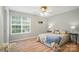 Sunlit bedroom with a large window, wood-look flooring, and calming neutral wall color at 317 Cedarcroft Dr, Mooresville, NC 28115