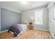 Bright bedroom featuring a single bed, neutral walls, wood-look flooring, and a window at 317 Cedarcroft Dr, Mooresville, NC 28115