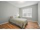 Bright bedroom featuring a single bed, neutral walls, wood-look flooring, and a window at 317 Cedarcroft Dr, Mooresville, NC 28115
