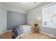 Bright bedroom featuring a single bed, neutral walls, wood-look flooring, and a window at 317 Cedarcroft Dr, Mooresville, NC 28115