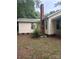 A view of the side of the home, featuring a brick chimney and yellow siding at 343 Dayvault Sw St, Concord, NC 28025