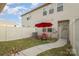 A cozy fenced backyard featuring a patio set with a red umbrella at 3436 Scottish Fern Ln # 172, Indian Land, SC 29707