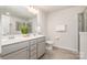 Well-lit bathroom featuring dual sinks, gray cabinets, tiled floors, and a walk-in shower for a spa-like experience at 3436 Scottish Fern Ln # 172, Indian Land, SC 29707