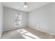 Bright bedroom features neutral carpeting, ceiling fan, and window letting in natural light at 3505 Frostmoor Pl, Charlotte, NC 28269