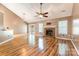 Bright living room with hardwood floors, a brick fireplace, and a ceiling fan at 3505 Frostmoor Pl, Charlotte, NC 28269