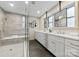 Bright bathroom featuring double vanity, sleek mirrors, and a spacious, tiled walk-in shower with a built-in bench at 3661 Annlin Ave, Charlotte, NC 28209