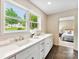 Bright bathroom with dual sink vanity, white cabinets, and views of the yard at 3661 Annlin Ave, Charlotte, NC 28209
