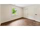 Bedroom featuring hardwood floors, a window, and ample closet space at 3661 Annlin Ave, Charlotte, NC 28209