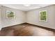 Bright bedroom with beautiful hardwood floors and two windows letting in natural light at 3661 Annlin Ave, Charlotte, NC 28209