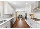 Open kitchen with stainless steel appliances, herringbone backsplash, and hardwood flooring at 3661 Annlin Ave, Charlotte, NC 28209