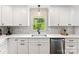 Bright kitchen with white cabinets, stainless steel appliances, and a view of the backyard at 3661 Annlin Ave, Charlotte, NC 28209